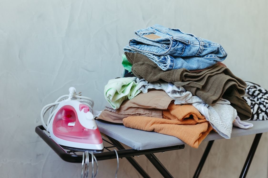 Iron beside a pile of clothes