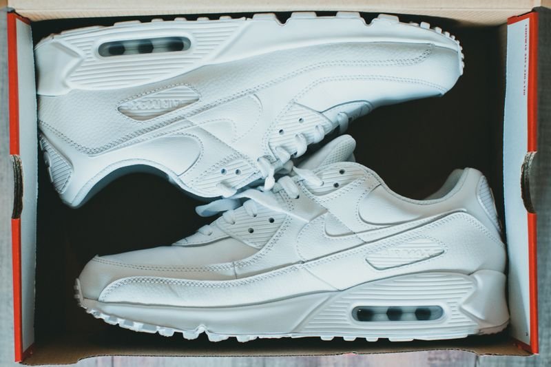 Clean white sneakers in a shoe box
